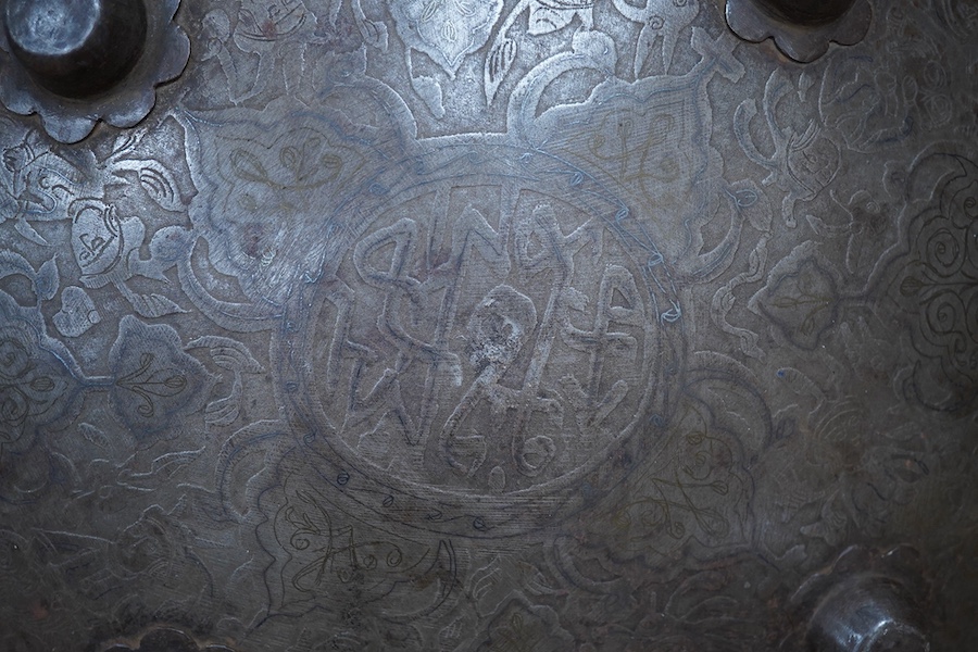 An early 20th century Persian steel shield dhal, 47cm diameter, with pairs of seated figures, brass reinforced brim, four central bosses, and silver and brass Damascene decoration, and four Burmese pottery vessels and a
